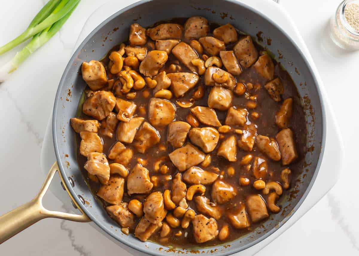 Chicken breast in a skillet with sauce.