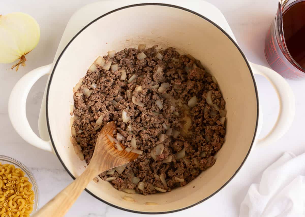 Ground beef sauteed in white pot.