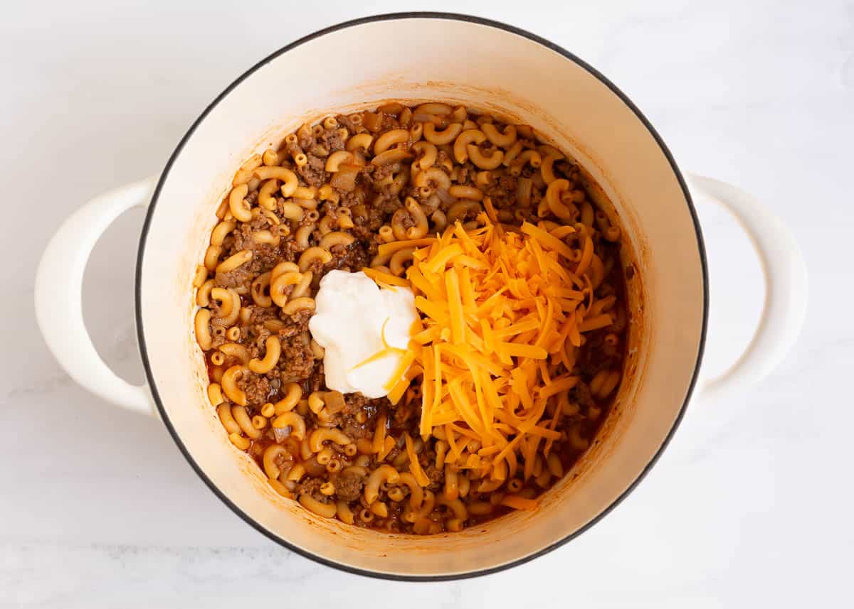 Cheese and sour cream with ground beef and noodles in a pot.