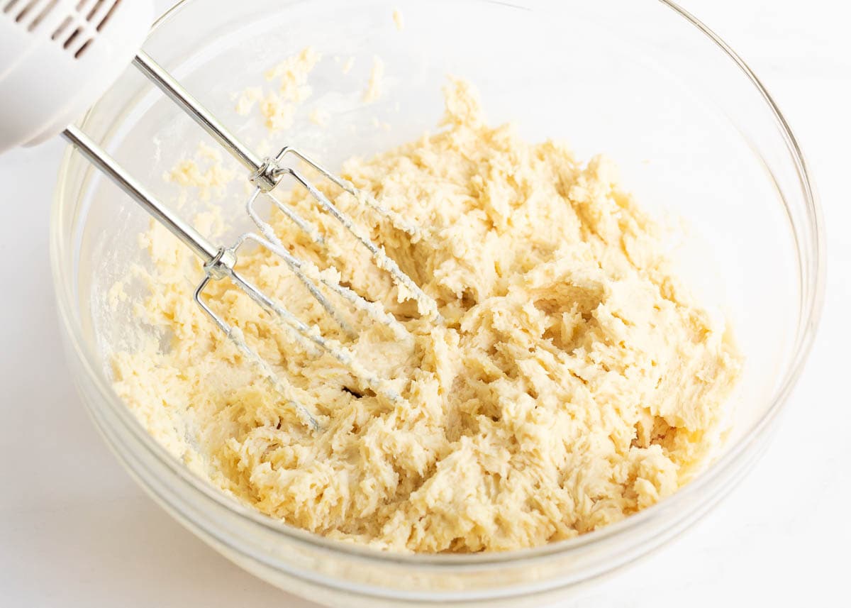 Cookie dough in a bowl with electric mixer.