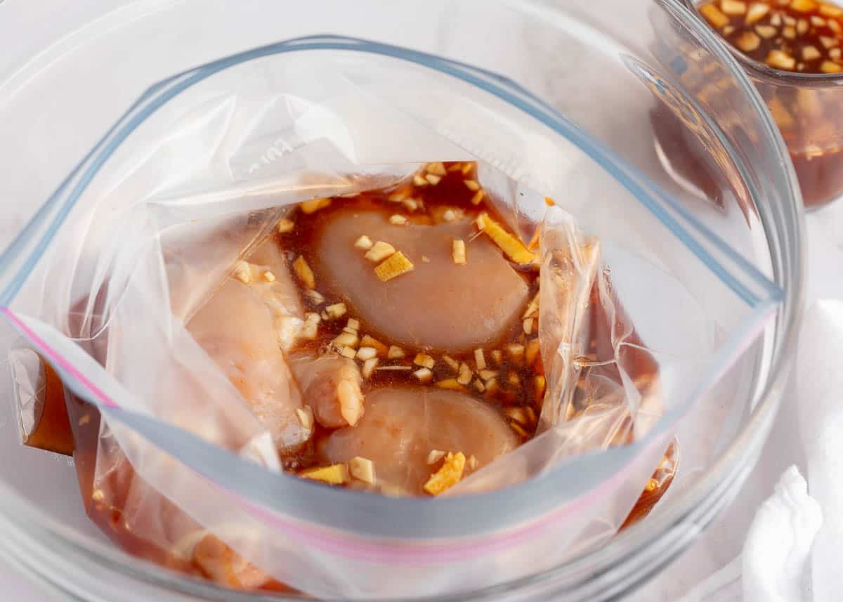 Chicken with marinade in a ziplock bag.