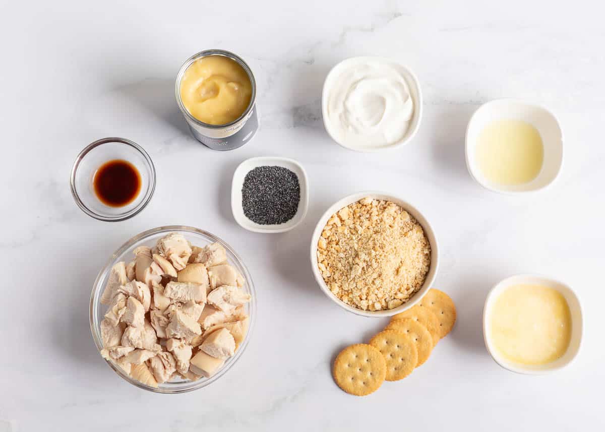 Cream of chicken soup, chicken, sour cream, mayo, butter, Ritz crackers and poppy seeds on the counter. 