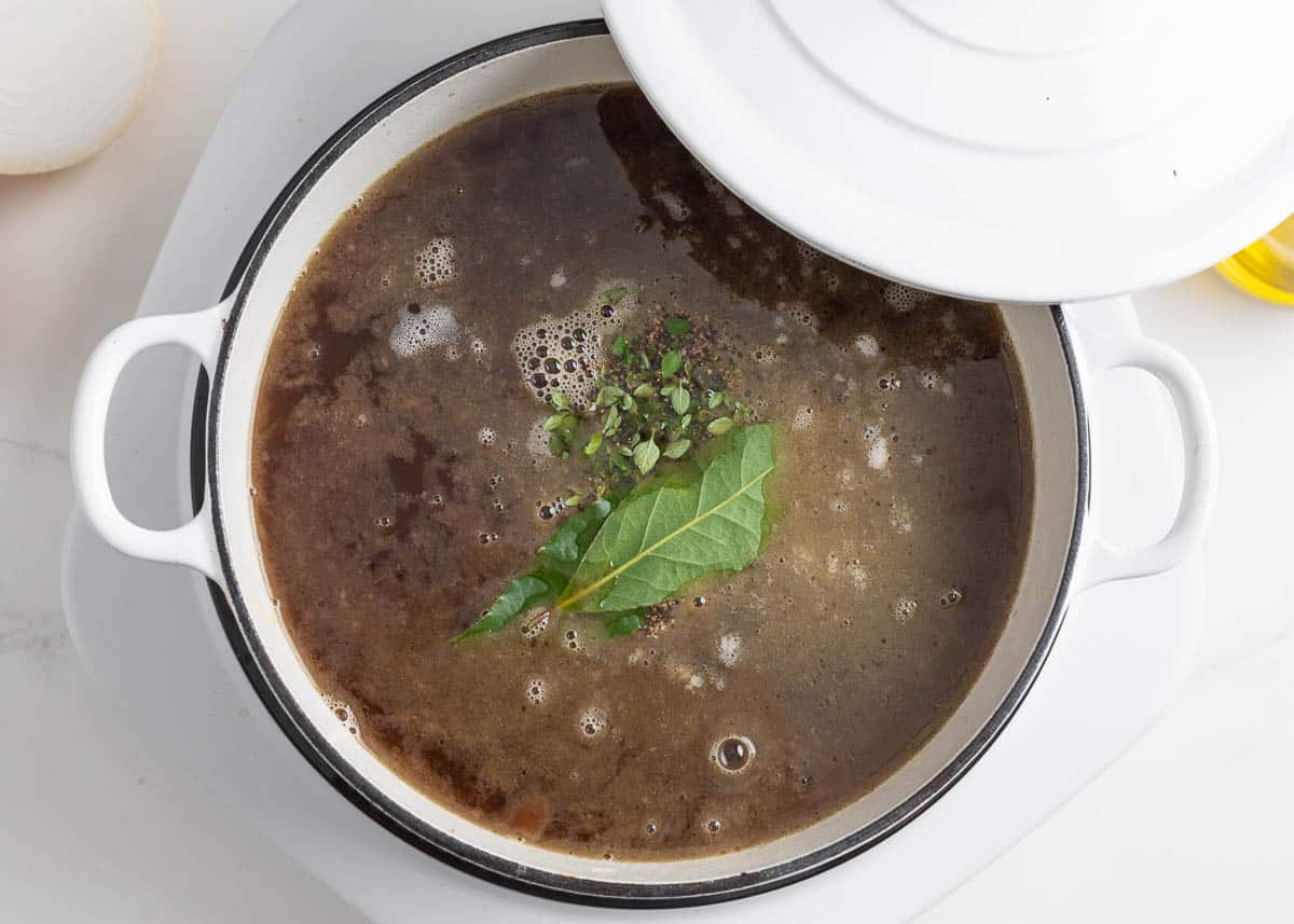 Simmering french onion soup in a pot.