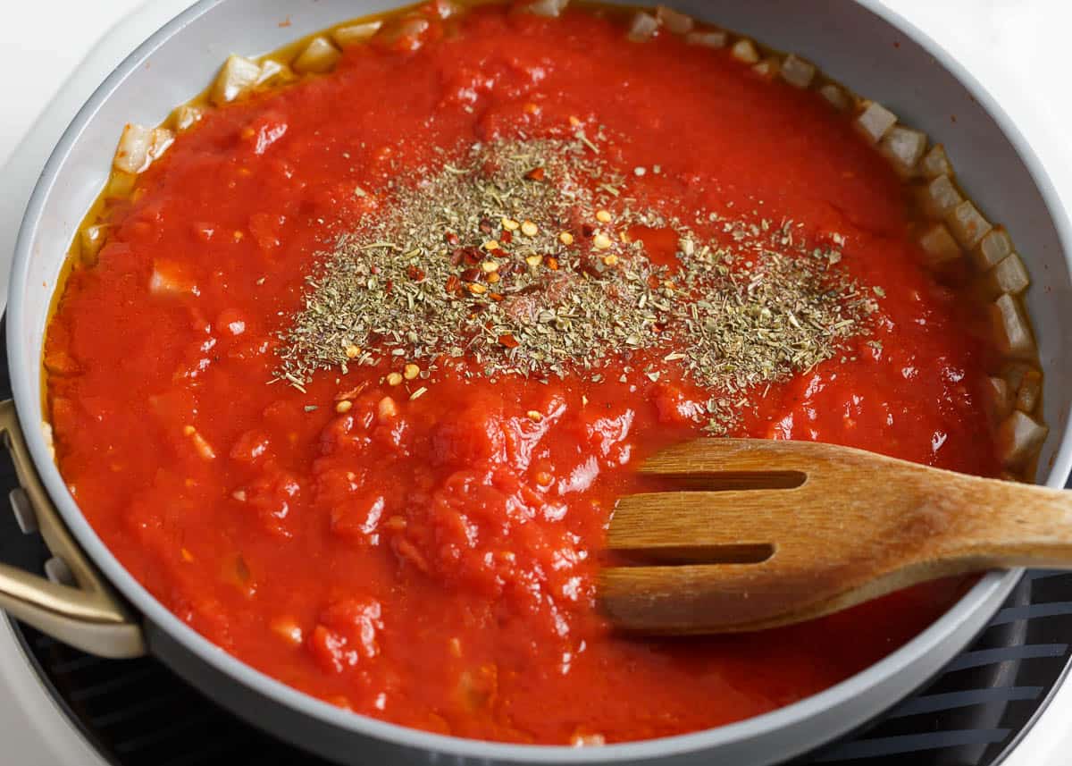 Tomatoes and seasoning in a skillet.