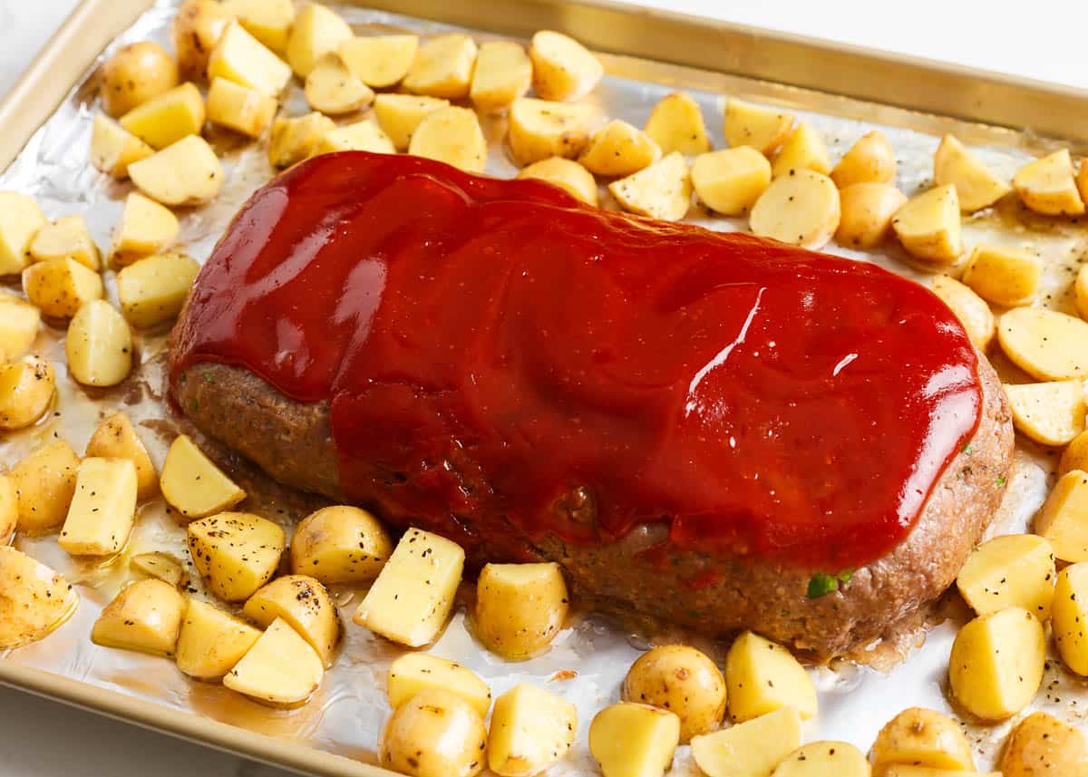 Sheet pan meatloaf with potatoes on a baking sheet.