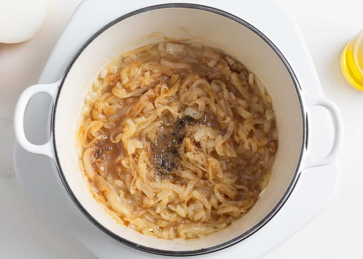 Cooking onions in a white pot.