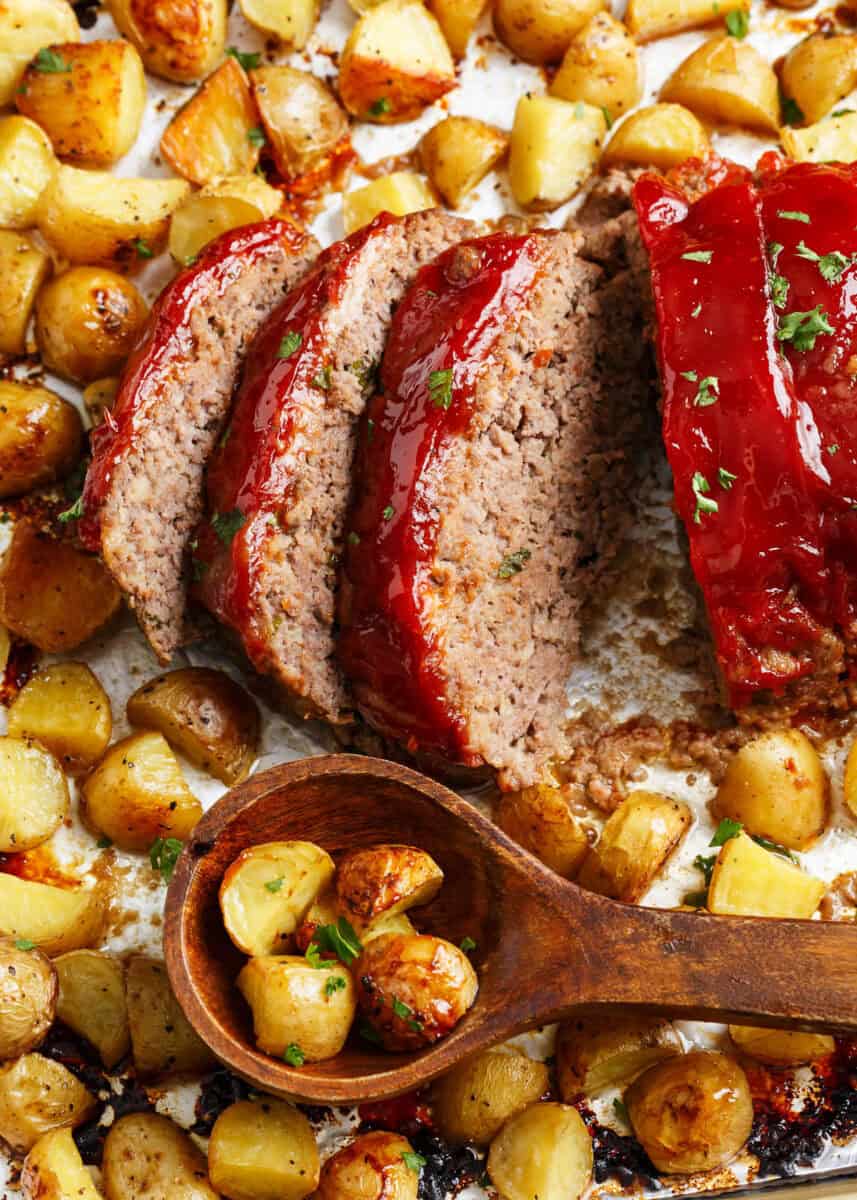 Close of up of sliced sheet pan meatloaf with potatoes.