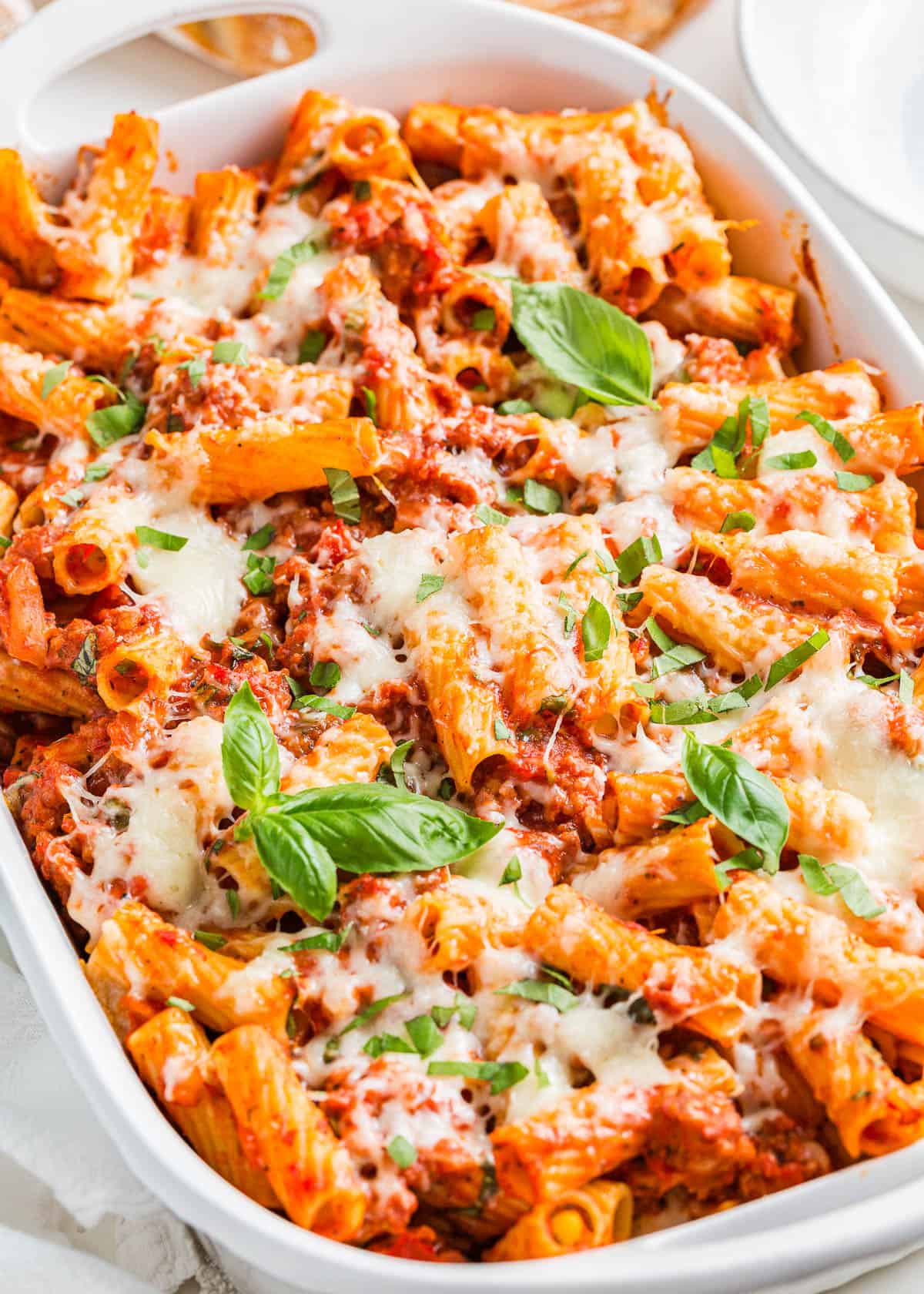 Baked rigatoni in a white dish.