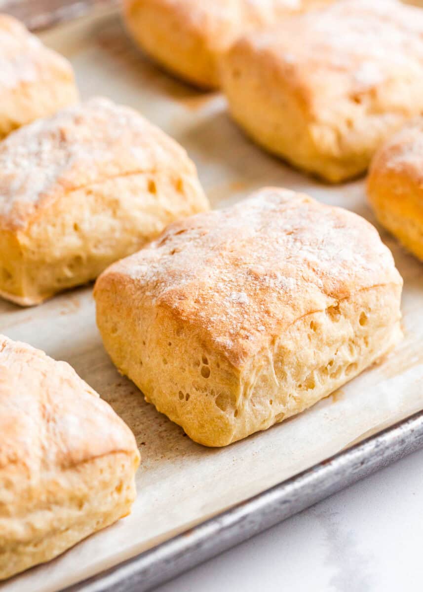 Ciabatta bread rolls on a pan.