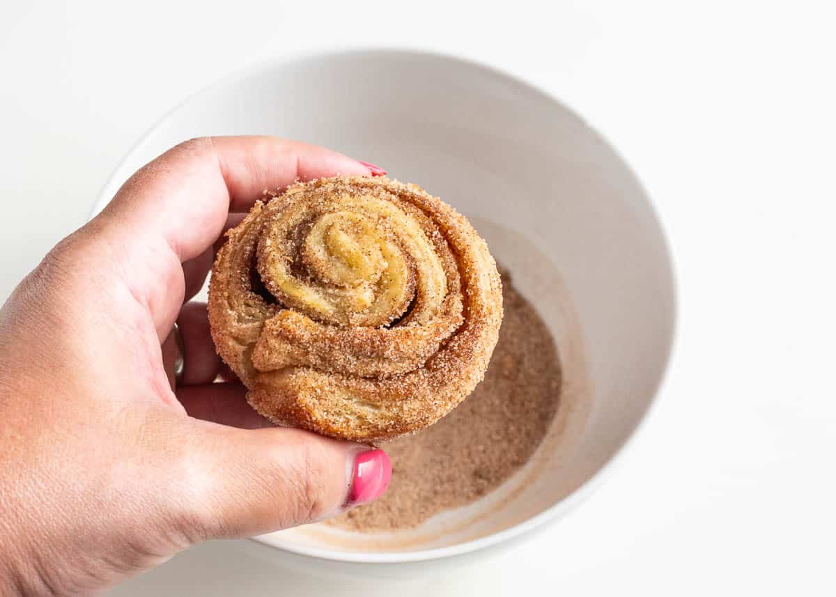 Dipping cruffin in cinnamon sugar.