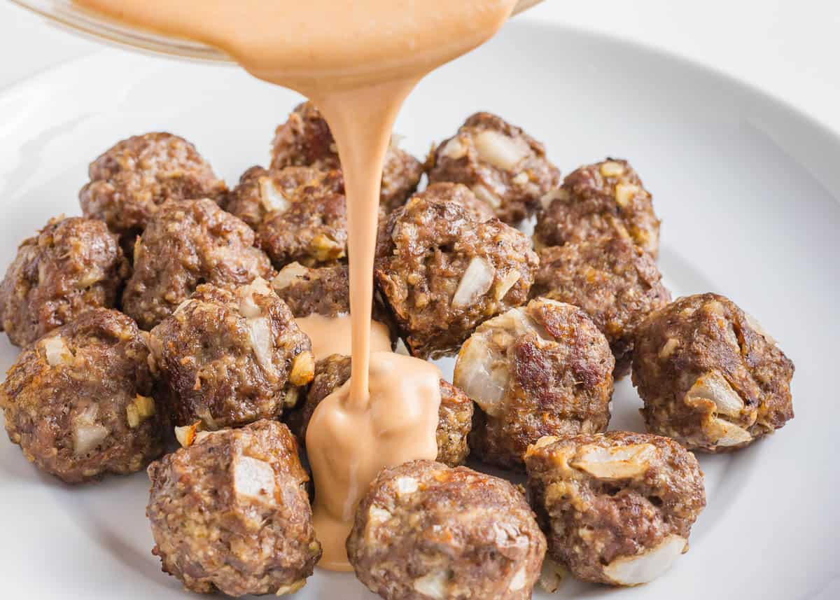 Pouring sauce over firecracker meatballs.