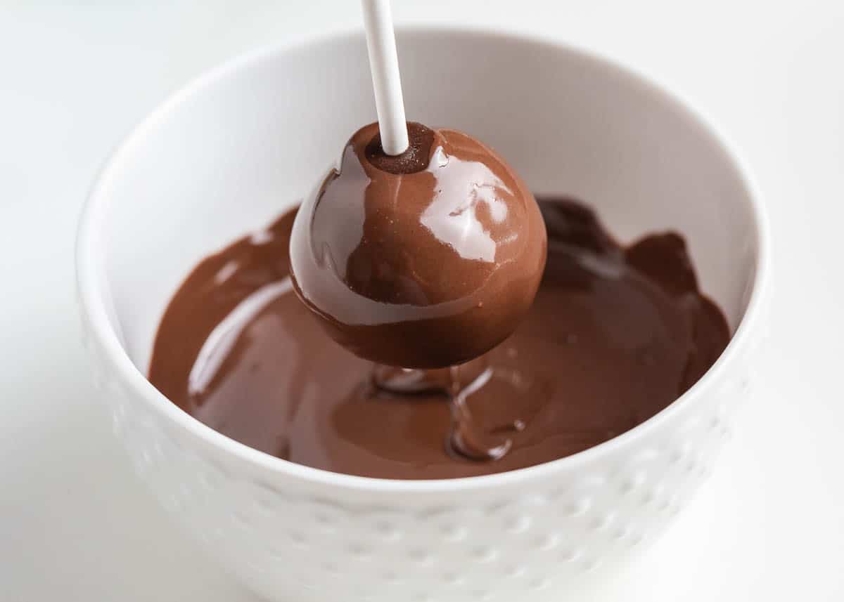 Dipping cake pops into the chocolate.