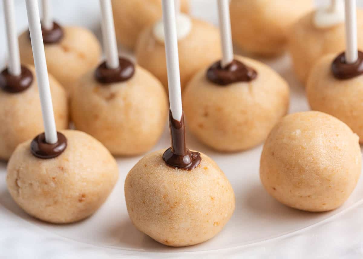 Dipping chocolate sticks into the cake balls.