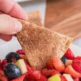 Dipping cinnamon tortilla chip in fruit salsa.