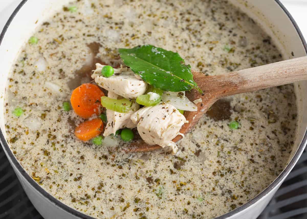 Showing how to make chicken dumplings soup in a pot.