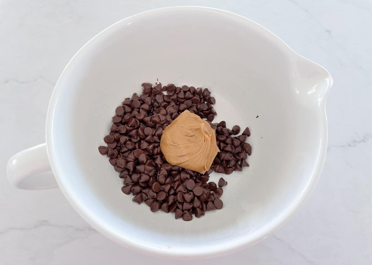 Peanut butter and chocolate chips ina microwave safe bowl.