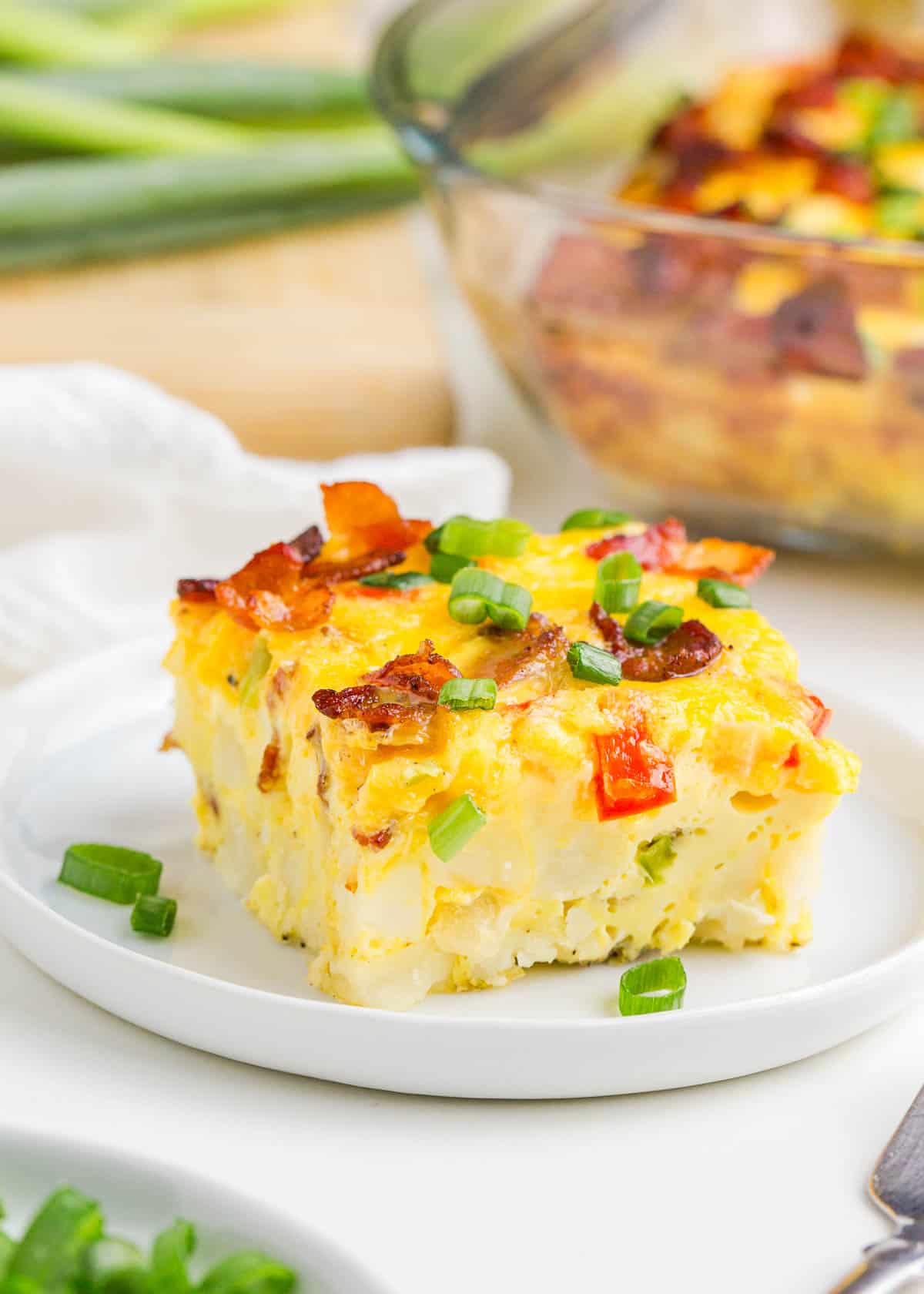 A slice of bacon, egg and potato casserole on a plate.