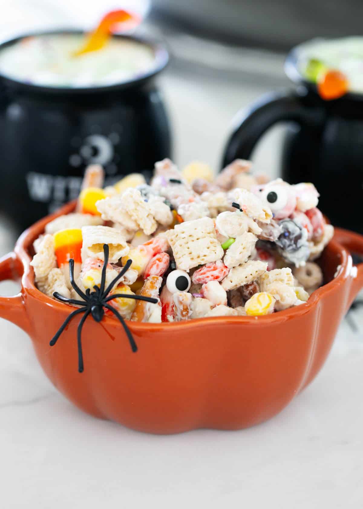 Halloween chex mix in a pumpkin bowl.