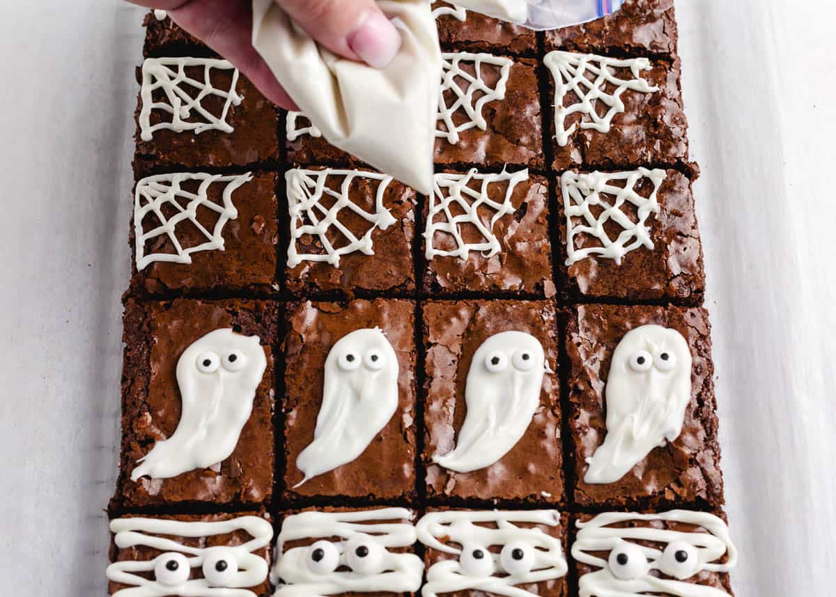 Drawing spider webs on Halloween brownies. 