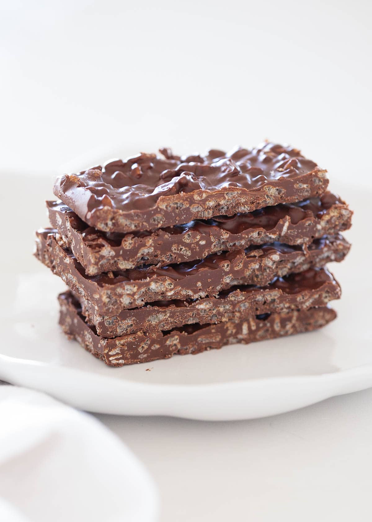 Five pieces of homemade crunch bars stacked on the counter. 