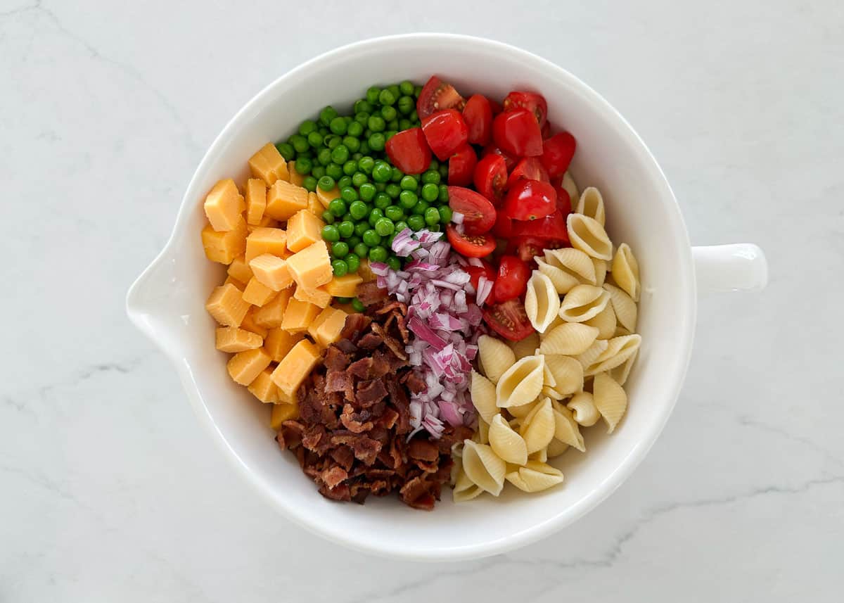 Bacon ranch pasta salad ingredients in a bowl.