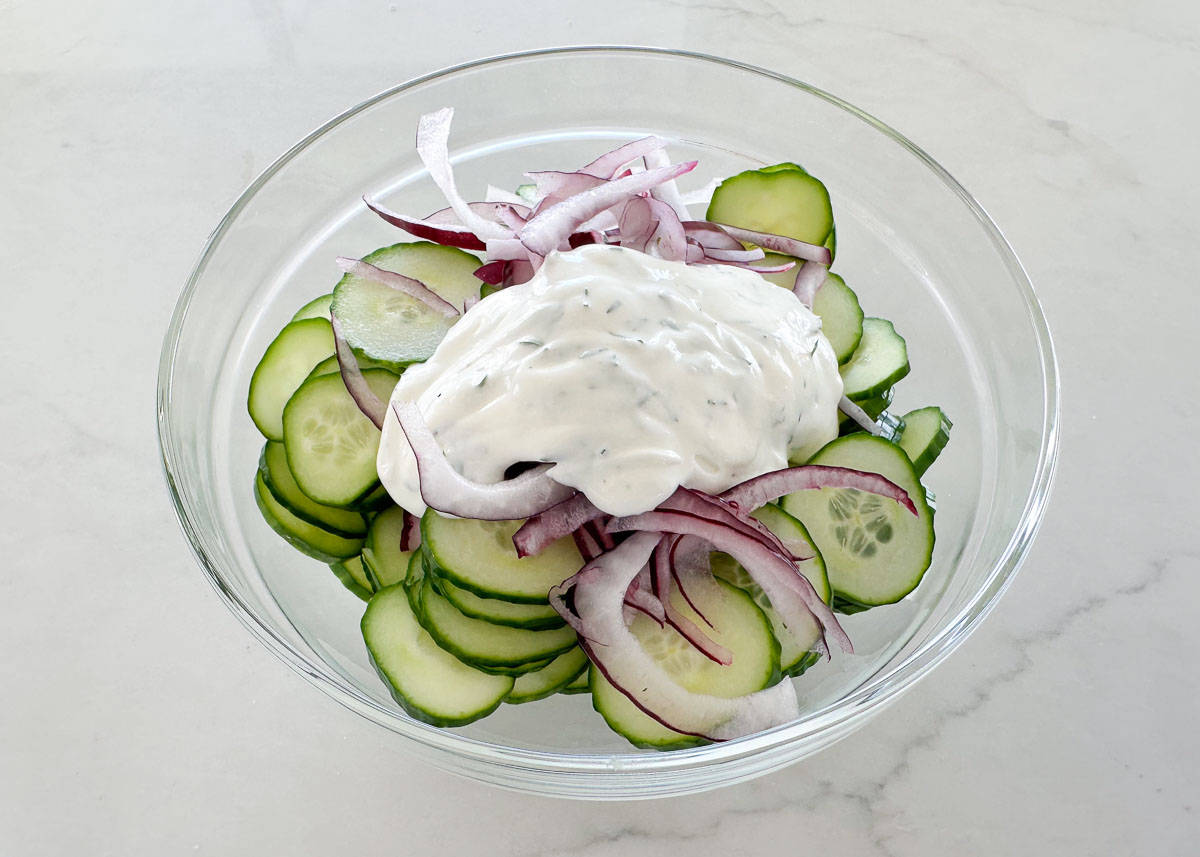 Showing how to make cucumber salad.