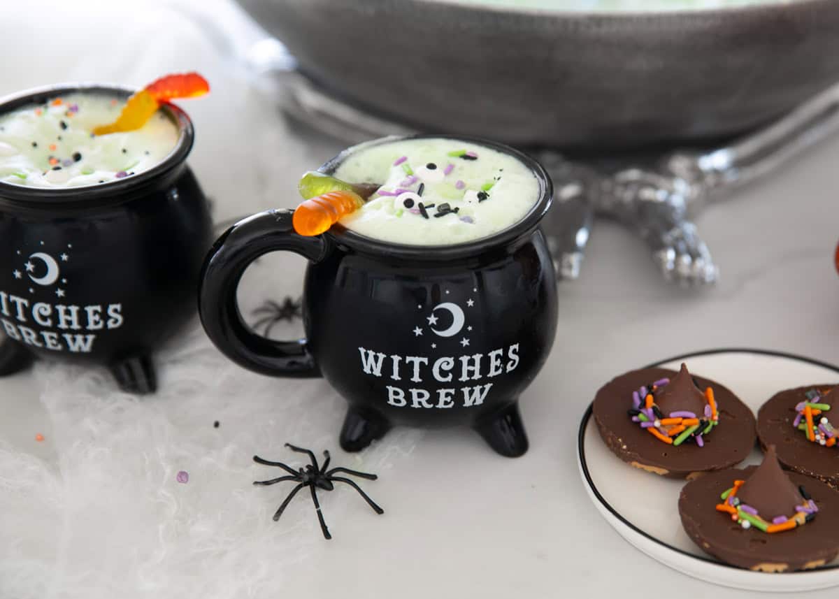 Witches brew in a cup with gummy worm as garnish.