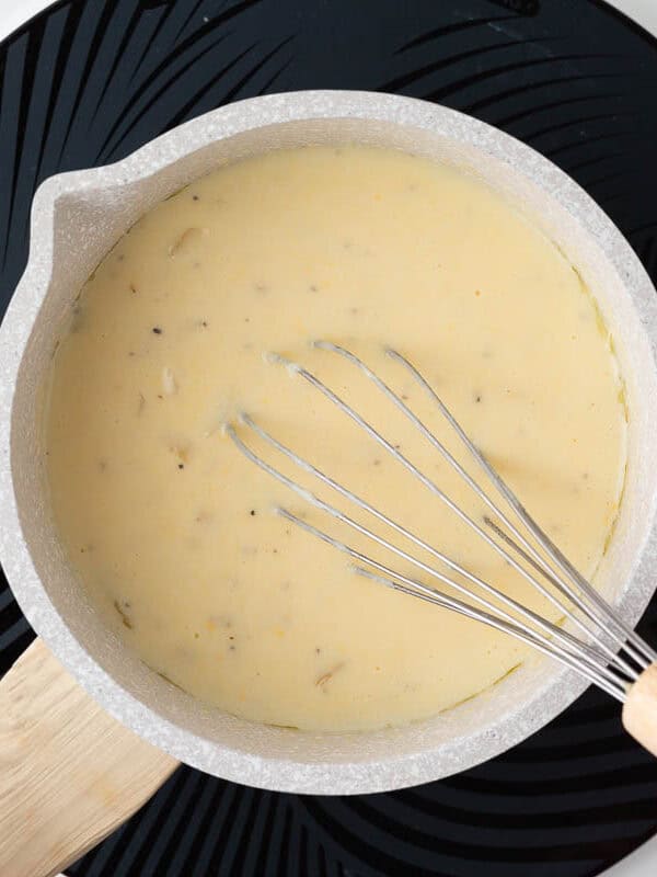 Making a sauce for scalloped potatoes in a saucepan.