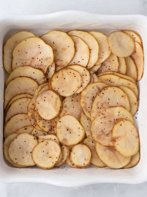 Sliced potatoes in baking dish.