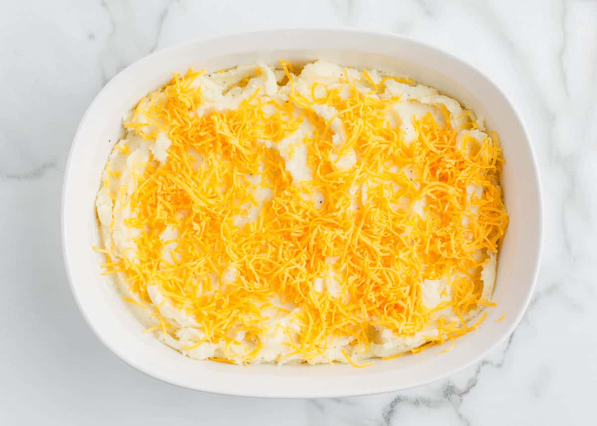 Mashed potatoes and cheese in baking dish.