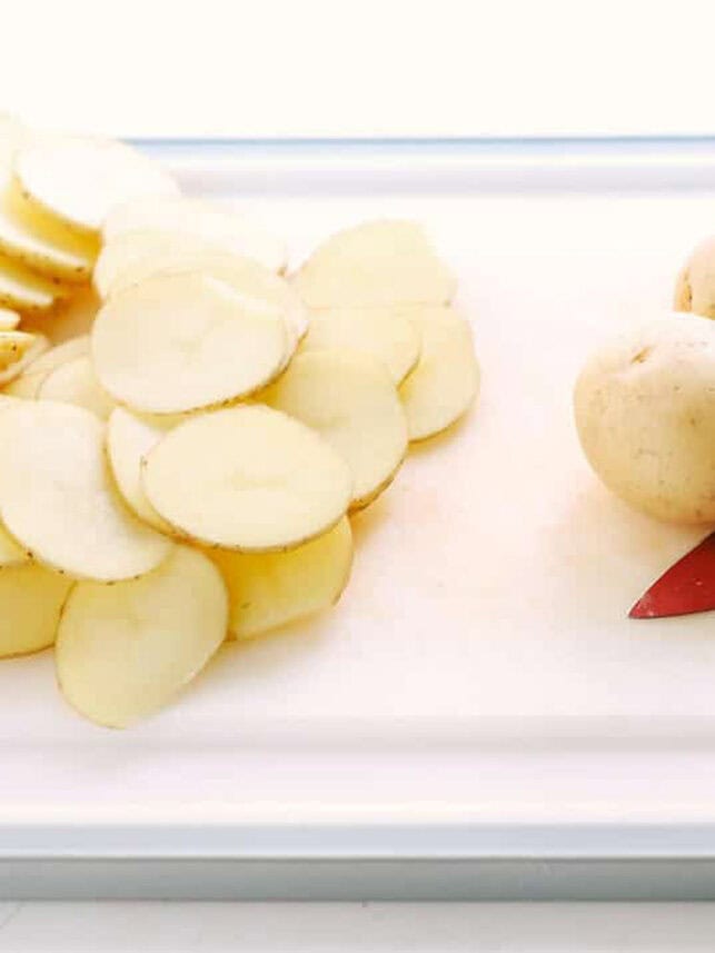 Sliced potatoes on a cutting board.