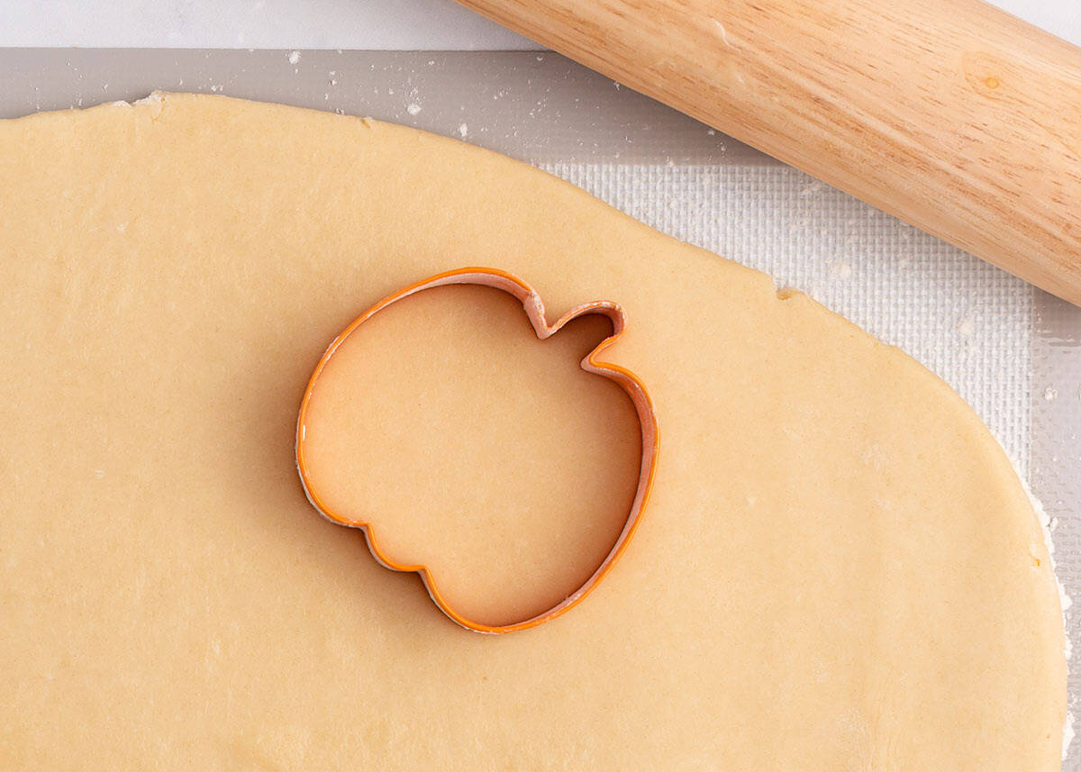 Showing how to make pumpkin cut out cookies.