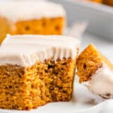 Pumpkin cake with a bite taken on white plate.