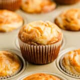 Pumpkin cream cheese muffins in a muffin pan.