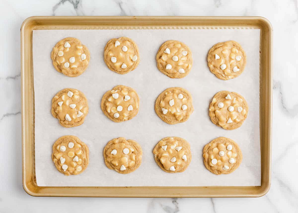 White chocolate chip cookies on a baking sheet.