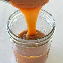 Pouring easy caramel sauce into jar.