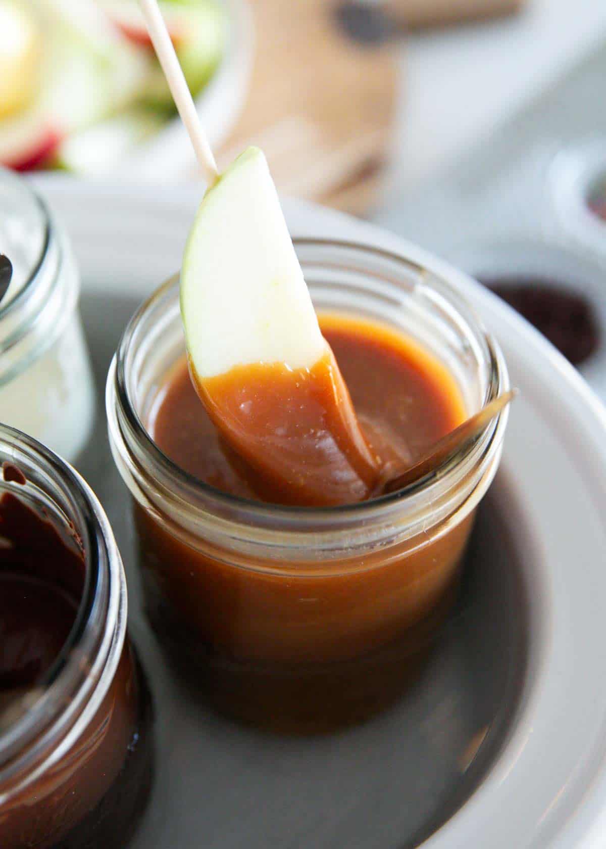 Dipping caramel in caramel sauce.