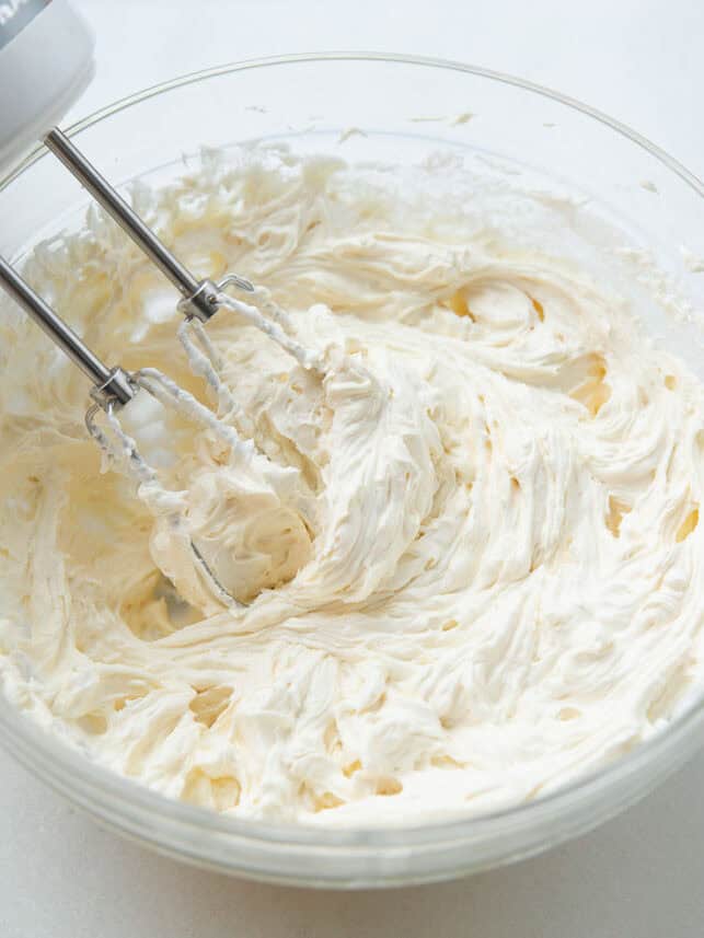 Cream cheese, butter and powdered sugar whipped in a bowl.