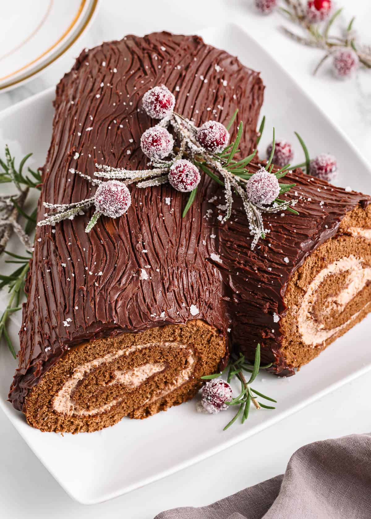 Yule log cake with cranberries on top.