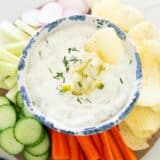 Dill pickle dip with vegetables and chips.