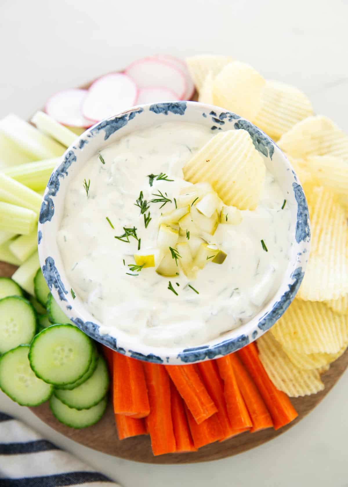 Dill pickle dip with vegetables and chips.