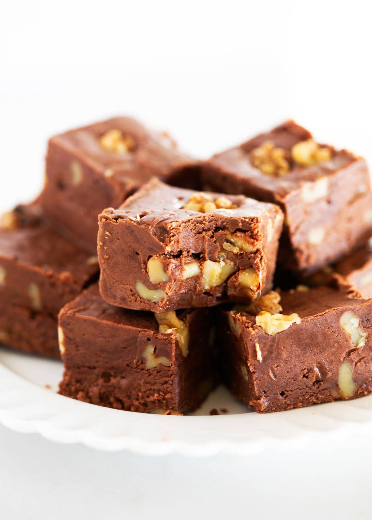 A plate of fantasy fudge with a bite missing out of one piece.