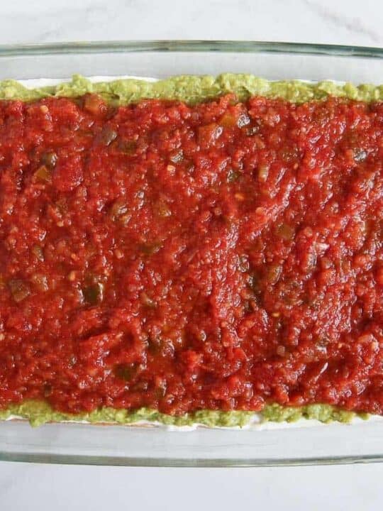 Salsa spread over guacamole layer for 7 layer dip.