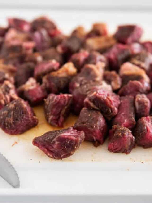 Steak cut into bites on a cutting board.