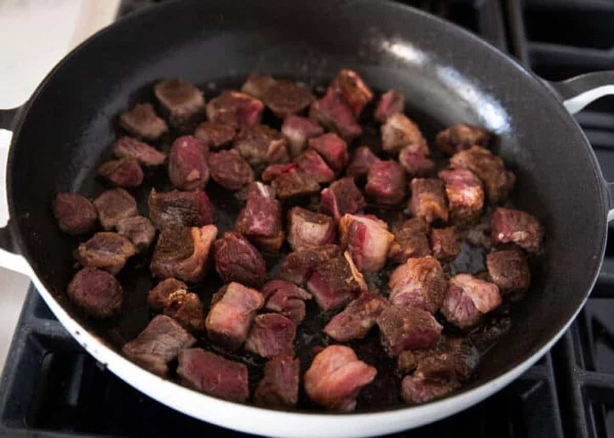 Searing steak in a skillet.