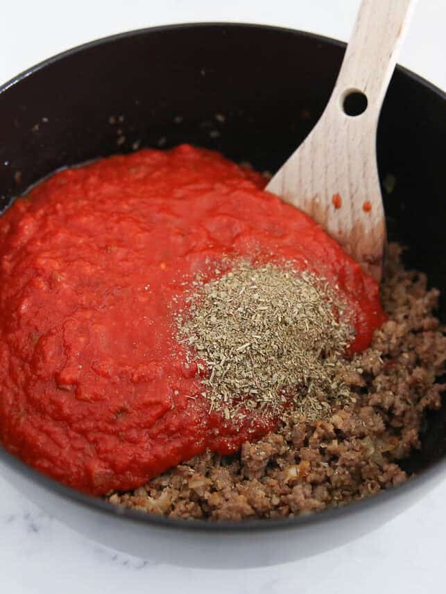 Sausage, onion, garlic, spaghetti sauce and italian seasoning in a pan.