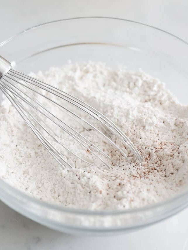 Flour, pumpkin pie spice and baking staples in a bowl.