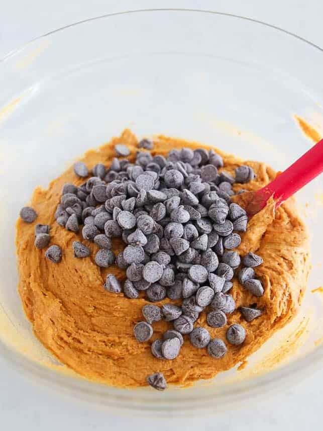 Cake mix, pumpkin puree and chocolate chips in a bowl.