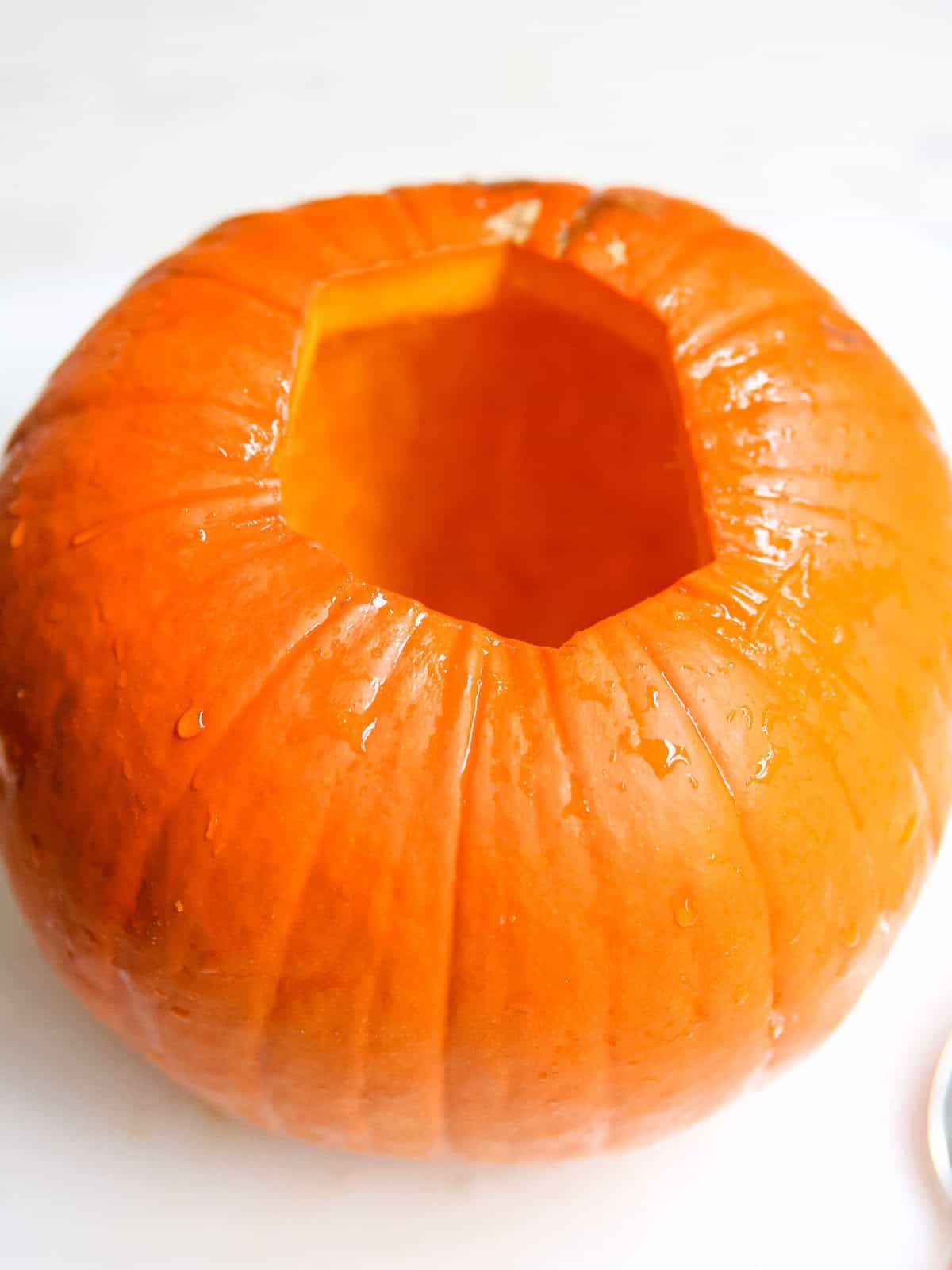 Showing how to slice a hole at the top of a pie pumpkin.