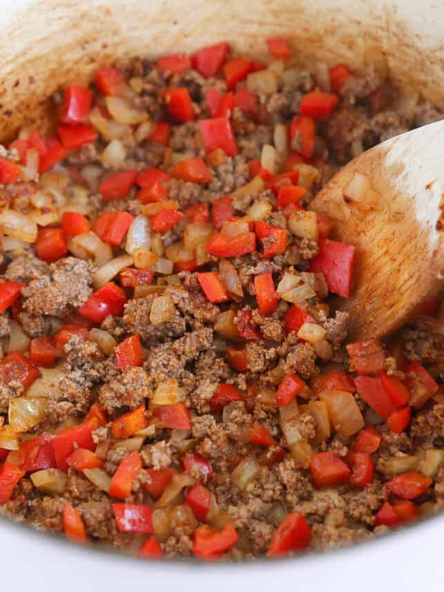 Sauteing onions, bell peppers and ground beef.